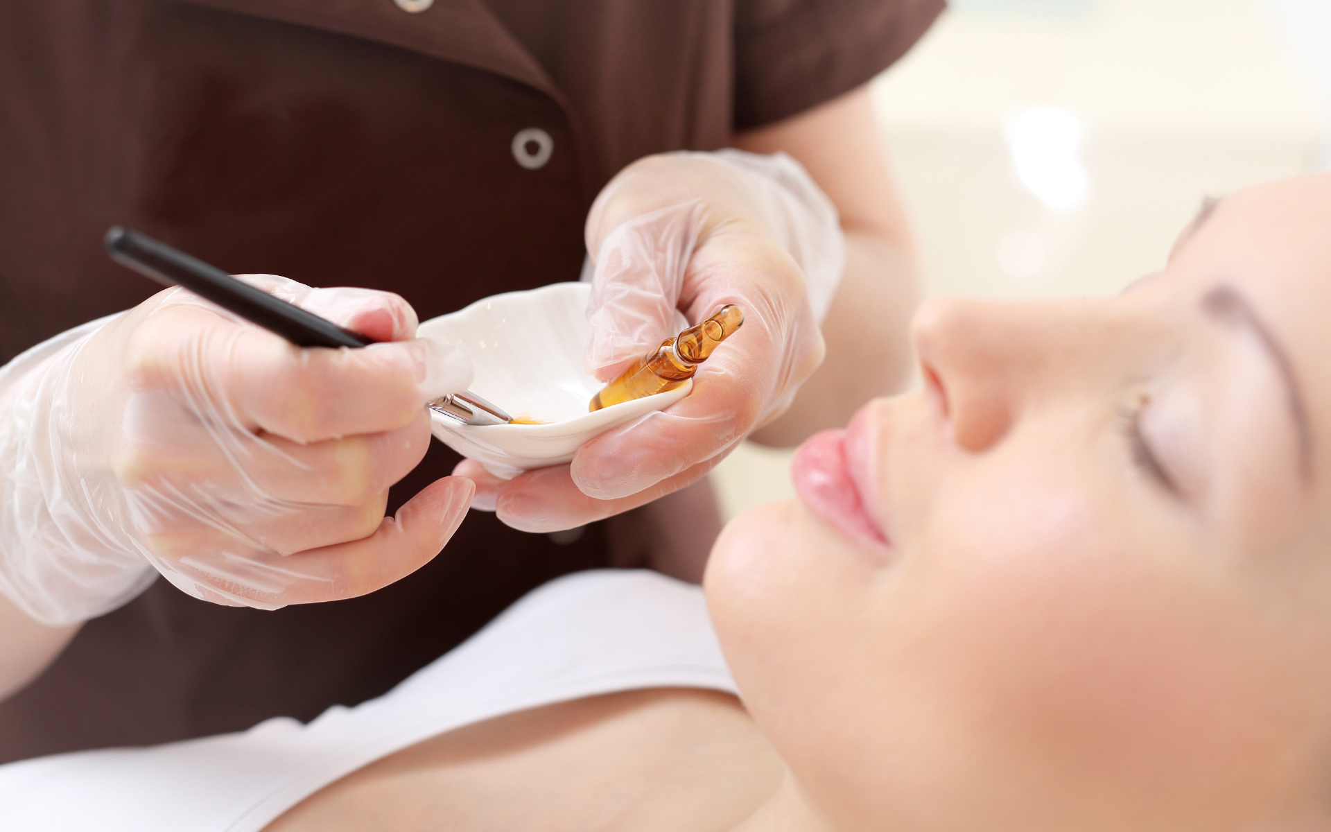 An image of a specialist getting ready to give a woman a chemical peel treatment on her face.