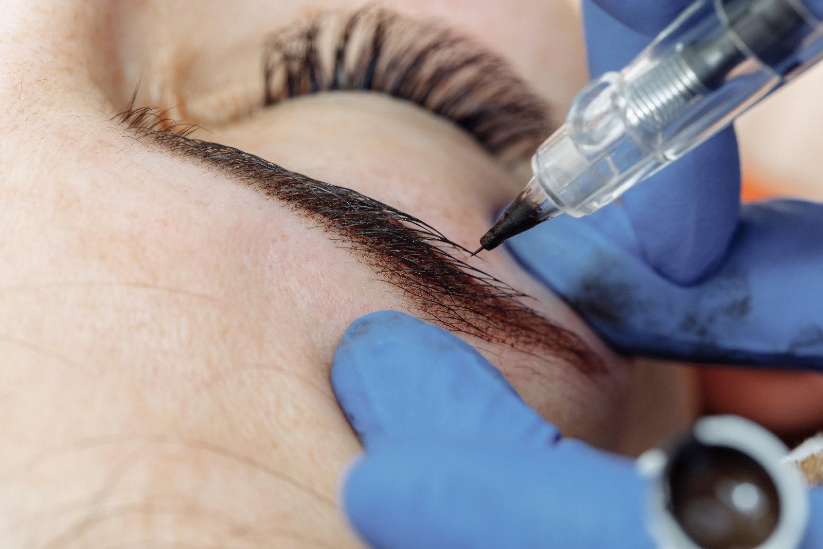 Permanent makeup, tattooing ofeyebrows. Cosmetologist applying makeup