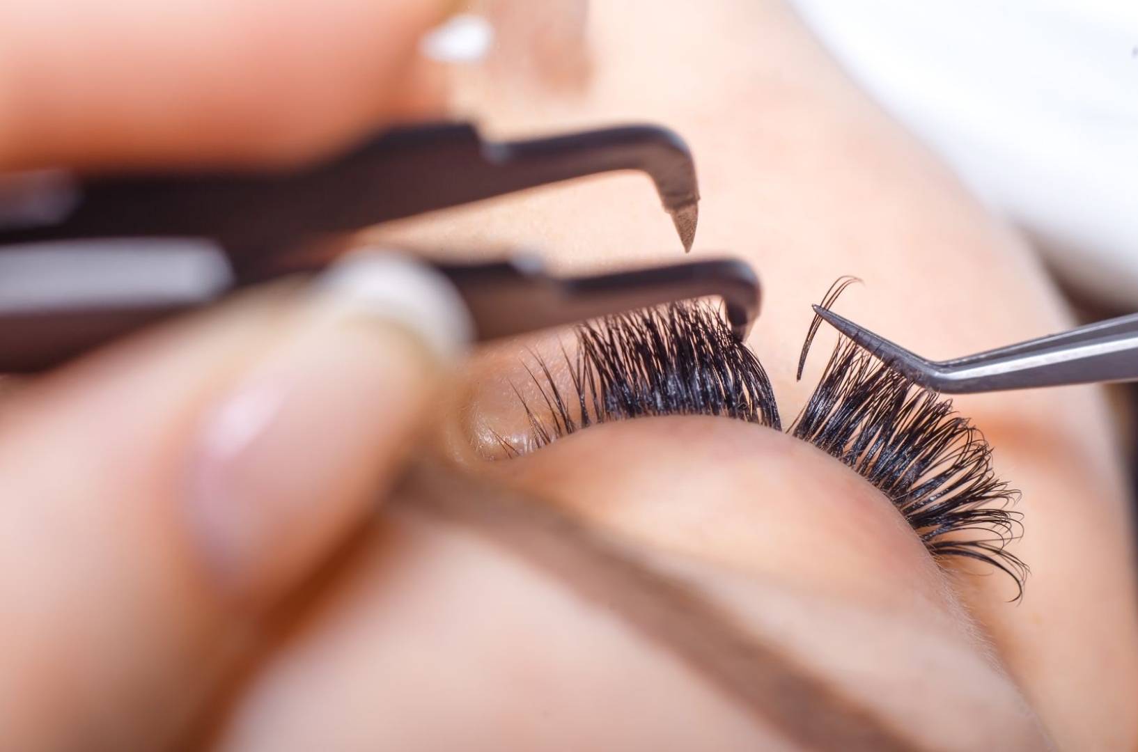 Woman organizing eyelash extensions in prep for eyelash extension appointment in Calgary.
